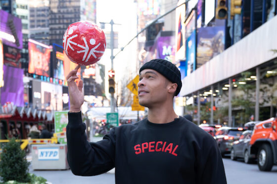Special Olympic Athlete in NY City for the Special Campaign launch wearing new sweatshirts and spinning Special Olympic logo designed ball on finger