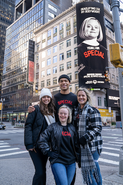 Special Olympics athletes, Madison Maddog Madory and Joshua Olds in NY for Special Campaign - the giant billboard is seen behind them on the building 