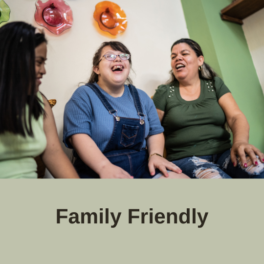 Photo created in non-profit canva account of three women with disabilities laughing. Text over a green background displays "family friendly" 