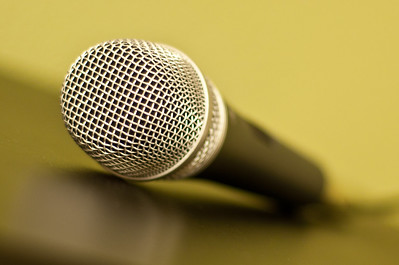 Photo attribution Flickr.com is a microphone laying on a yellow green background