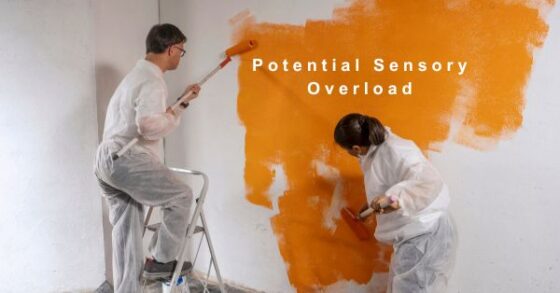 Photo of people with intellectual/developmental disabilities painting a white wall with rollers covered in bold orange paint. The image contains text that reads "Potential Sensory Overload" 
